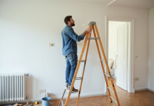 Homme en workwear peignant un mur dans un appartement français